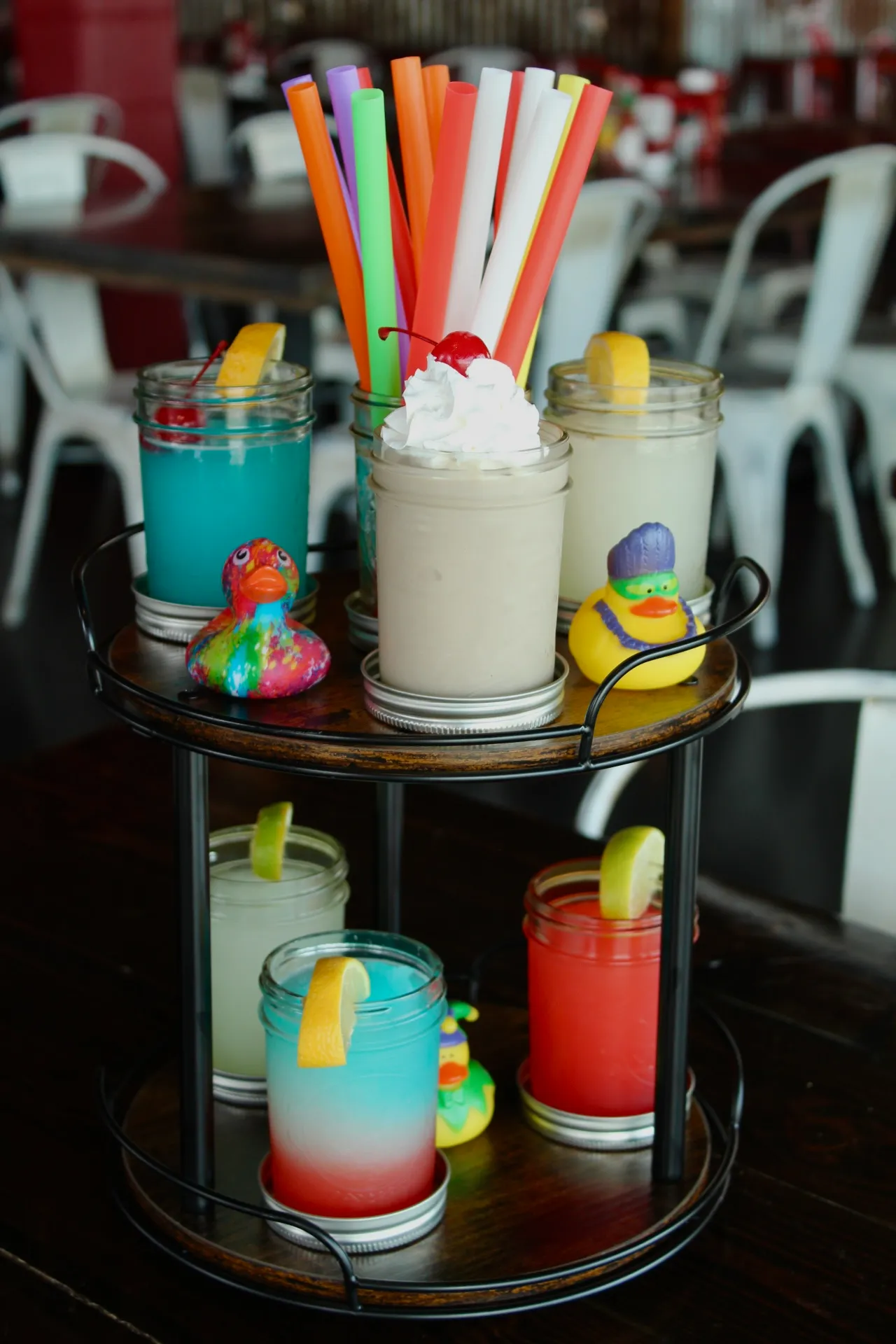 BOUGIE BOOZY SLUSHIE FLIGHT A colorful flight of slushies with various flavors and a cherry on top.