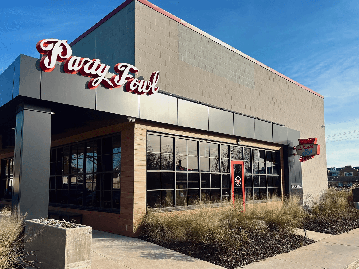 Ruston Party Fowl A modern restaurant with a sign reading 'Party Fowl' and a clear blue sky in the background.